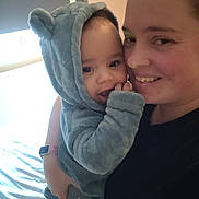 Elijah is registered to the contest to win money with this photo: adult, baby, bed, blanket, child, cozy, cute, face, fuzzy, happy, holding, home, hoodie, indoor, parent, person, portrait, smiling, toddler, wearing