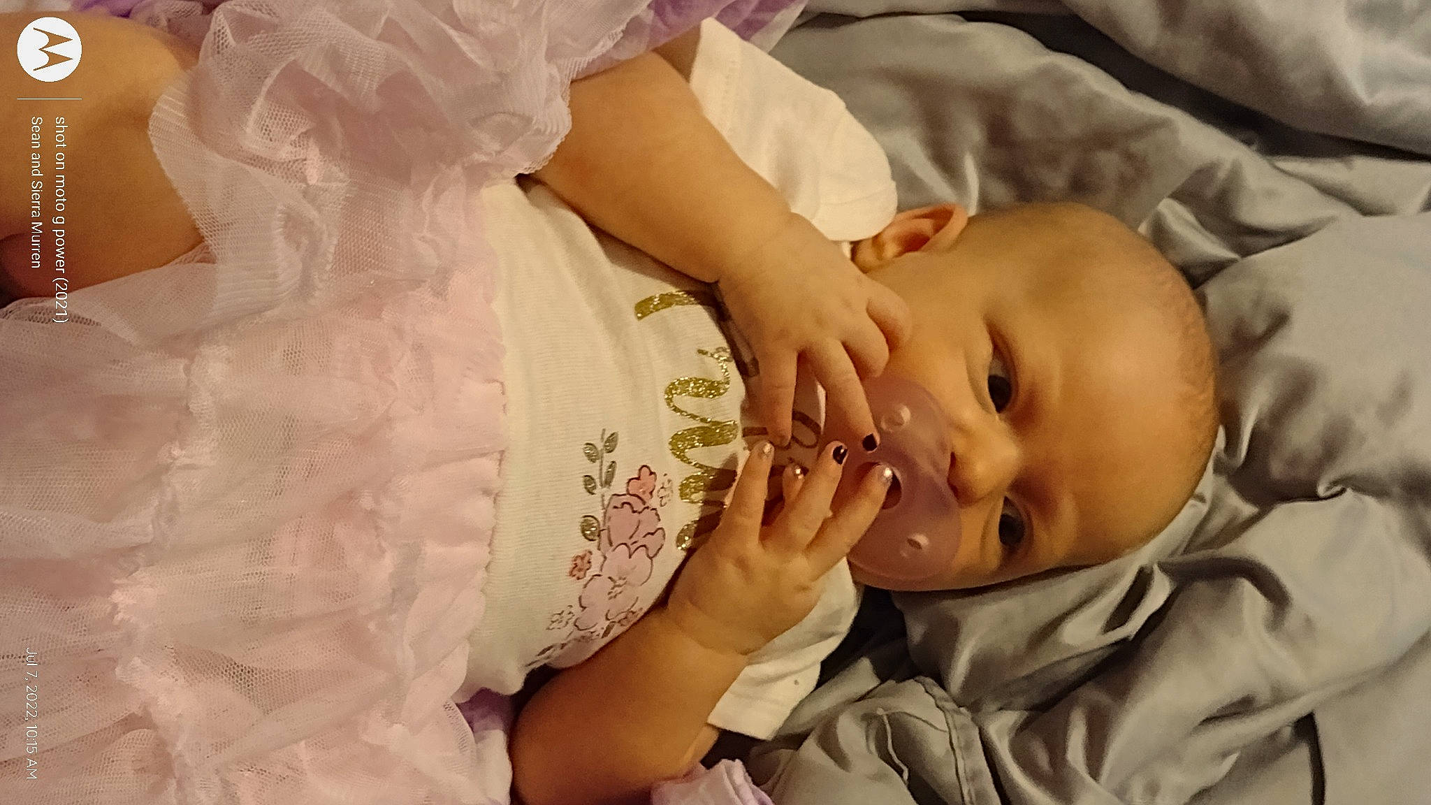 Lilith is registered to the contest to win money with this photo: baby, baby_toddler_clothing, cheek, child, close_up, comfort, embellishment, eye, finger, gesture, hand, happy, lip, nail, nose, pattern, person, skin, sleeve, thumb