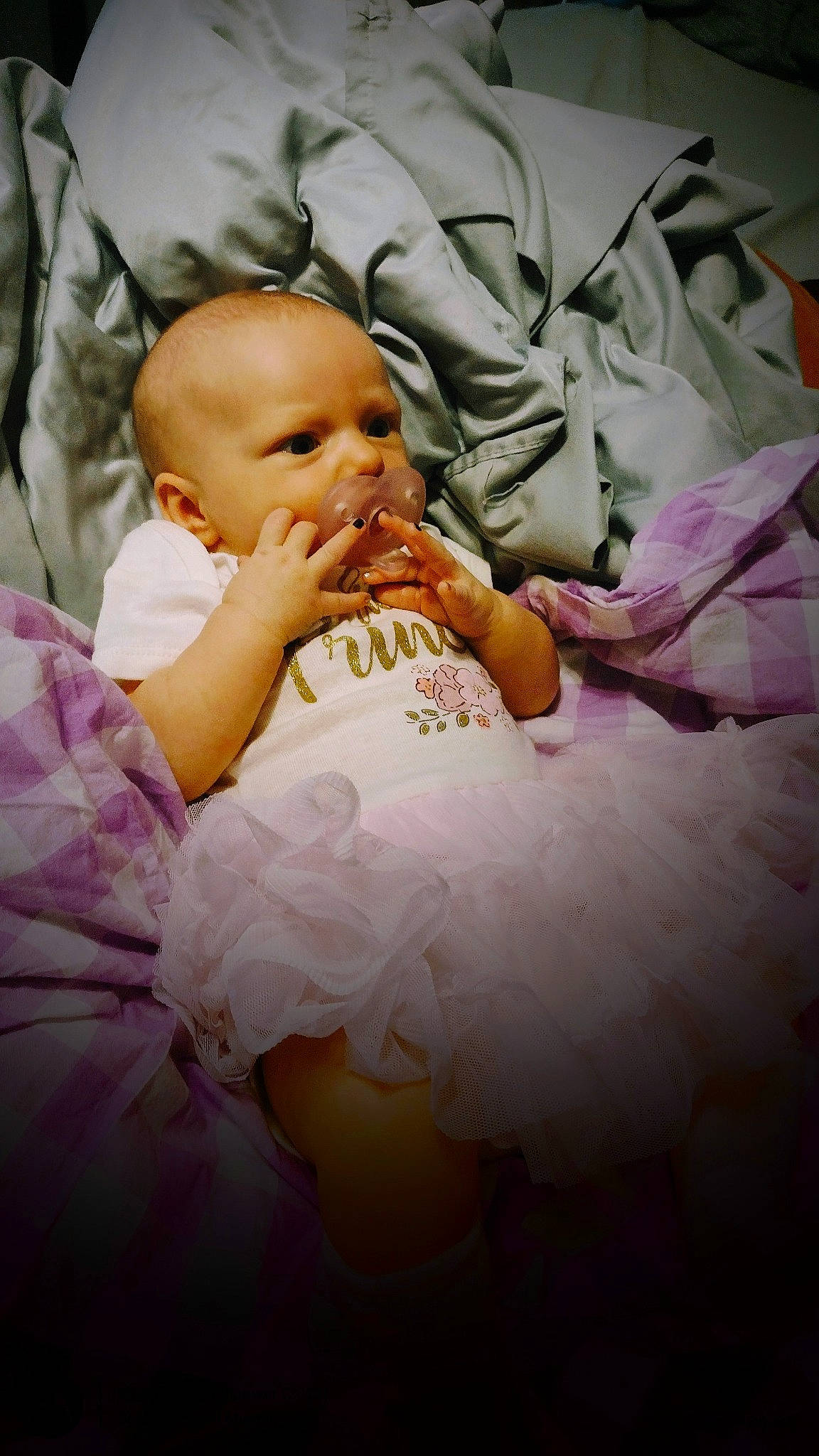 Lilith is registered to the contest to win money with this photo: abdomen, baby, baby_toddler_clothing, cheek, comfort, finger, flash_photography, gesture, hand, happy, head, iris, linens, lip, nail, person, pink, sitting, skin, thumb