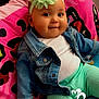 baby, child, denim_jacket, headband, flower, pink_blanket, colorful_blanket, smile, cute, indoors, portrait, happy, toddler, clothing, sitting, furniture, person, cozy, face, playful
