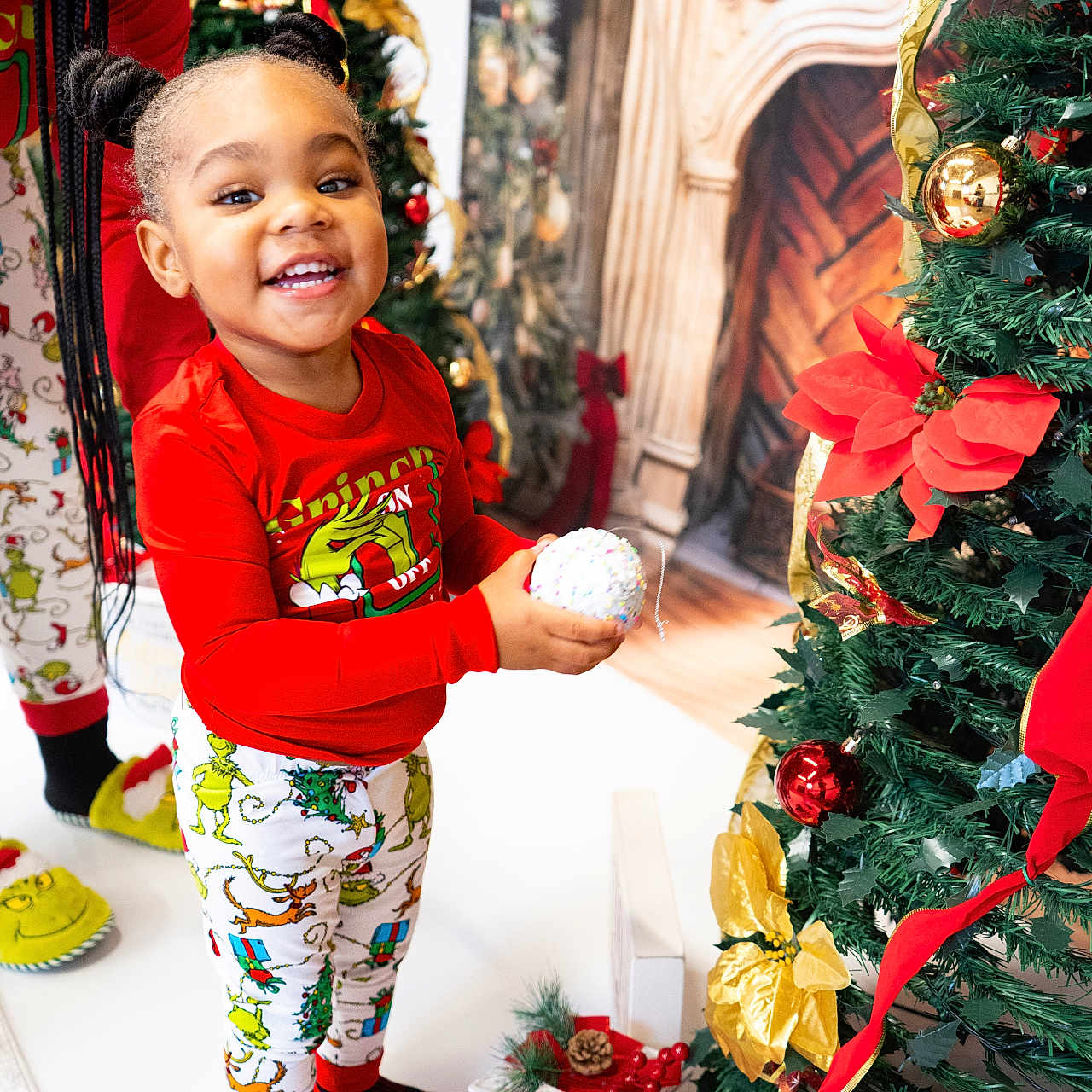 A'Keloni Dior Davis is registered to the contest to win money with this photo: adult, celebration, child, christmas_tree, decorations, festive, fireplace_backdrop, gift_box, happy, holiday, indoor, ornament, pajamas, pinecone, portrait, present, red_shirt, ribbon, smiling, socks