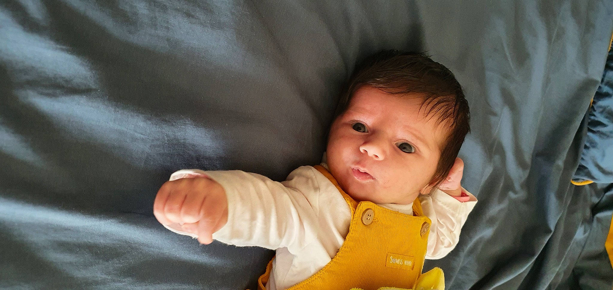 Inès participe au concours pour gagner de l'argent avec cette photo : baby, baby_products, baby_toddler_clothing, cheek, child, comfort, finger, fun, gesture, happy, iris, jacket, linens, nose, outerwear, person, sitting, skin, sleeve, thumb