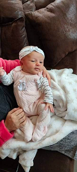 Loéline participe au concours pour gagner de l'argent avec cette photo : baby, baby_products, baby_toddler_clothing, cap, cheek, child, comfort, eye, finger, fur, hat, headwear, knit_cap, linens, lip, person, pink, sitting, skin, sleeve