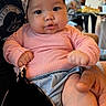 Kristyn is registered to the contest to win money with this photo: baby, child, infant, pink_sweater, headband, person, indoor, hand, blurred_background, seated, cute, chubby_cheeks, casual, portrait, soft_lighting, people, table, clothing, holding, face