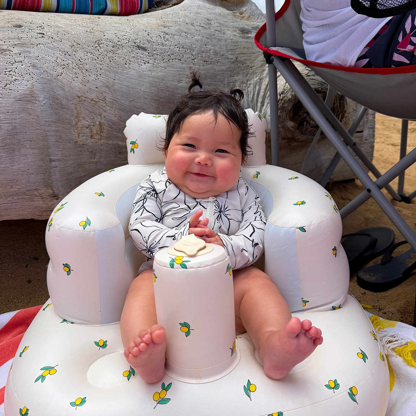 Kristyn joined the competition — help win amazing prizes! baby, inflatable_chair, smiling, beach, outdoor, child, pigtails, happy, foot, sitting, white, yellow, pattern, clothing, person, sand, chair, towel, tree, relaxation