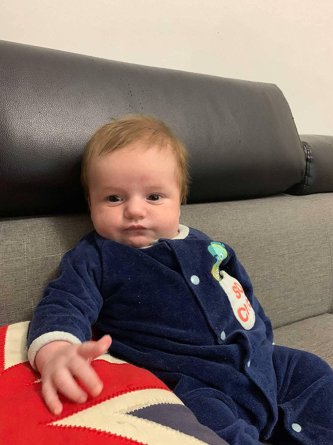 Tommy a rejoint le concours — aidez-le/la à gagner de superbes lots ! auto_part, baby, baby_toddler_clothing, carmine, cheek, child, comfort, couch, flooring, human_leg, lap, linens, person, room, sitting, sleeve, toddler