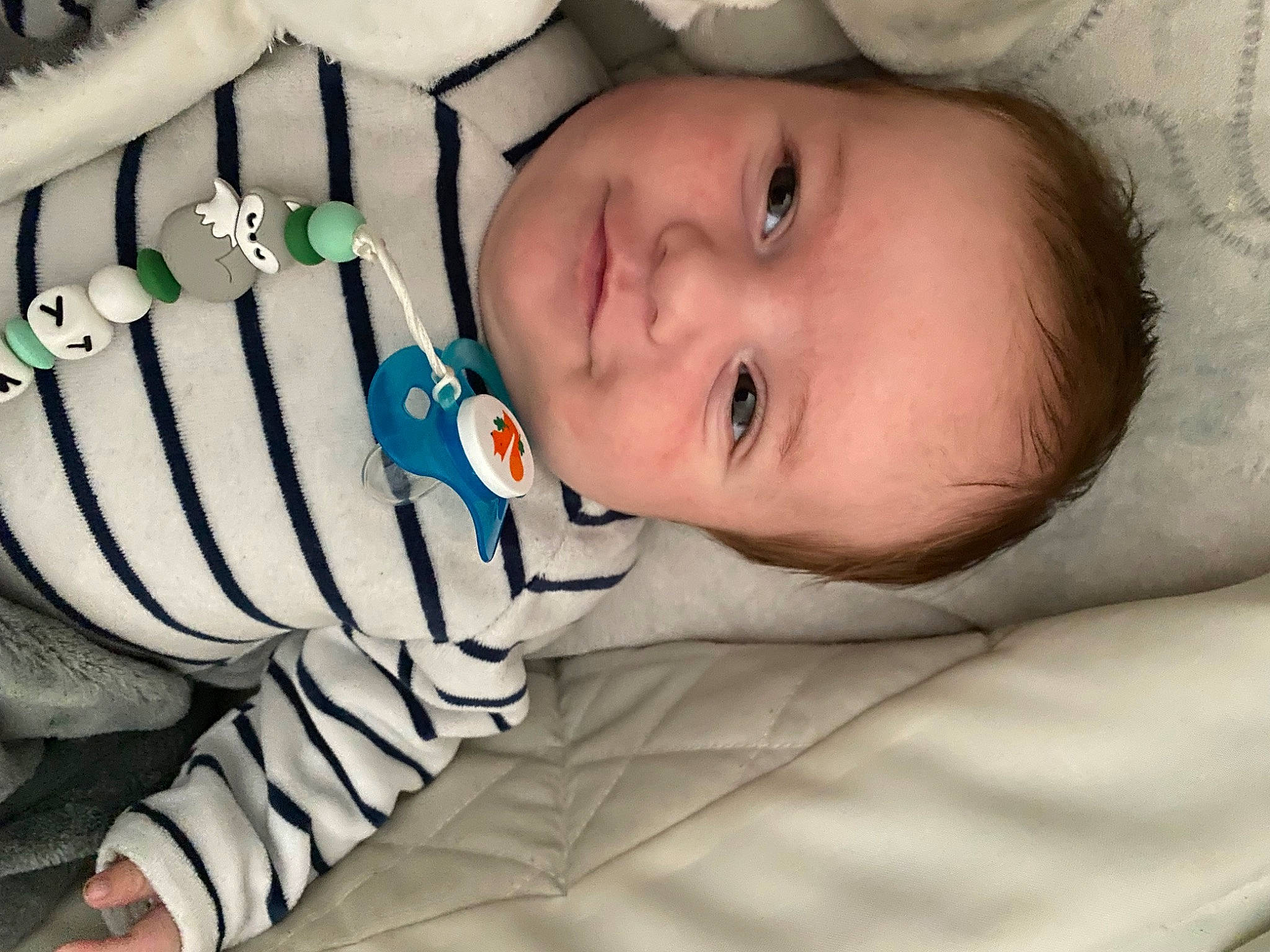 Tommy a rejoint le concours — aidez-le/la à gagner de superbes lots ! arm, baby, baby_toddler_clothing, cheek, child, comfort, eye, eyelash, flash_photography, happy, iris, linens, mouth, neck, pattern, person, room, skin, smile, textile