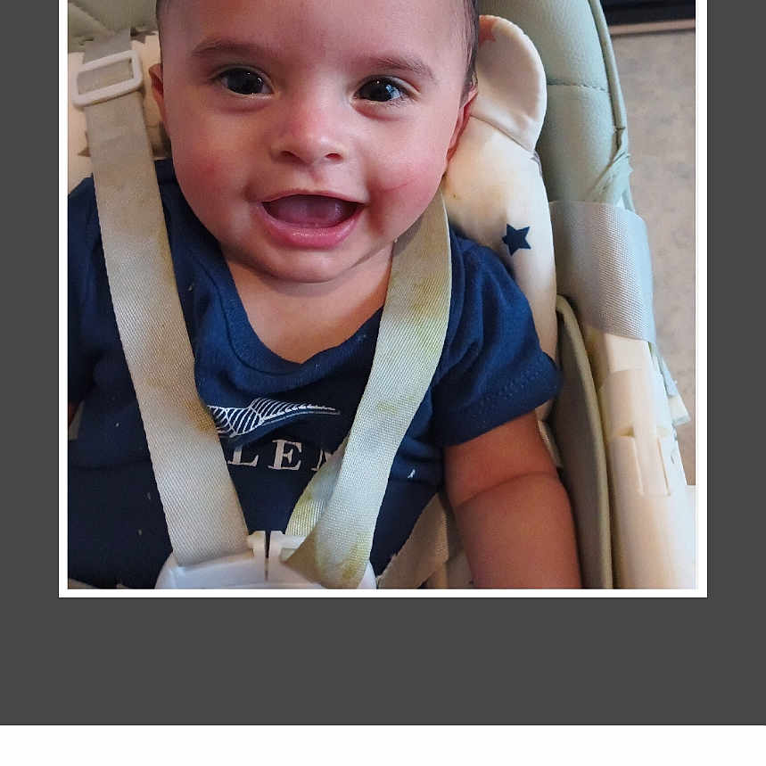 Télio a rejoint le concours — aidez-le/la à gagner de superbes lots ! baby, baby_clothes, child, closeup, clothing, face, furniture, happy, high_chair, indoor, infant, living_room, person, screen, seat, seatbelt, smiling, table, television, toy