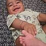 baby, smiling, infant, bracelet, foot, hand, patterned_bedspread, animal_print, clothing, diaper, lying_down, cute, happy, close_up, indoor, person, child, young, playful, skin