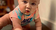 Paris is registered to the contest to win money with this photo: baby, crawling, child, indoor, carpet, onesie, nike, curious, portrait, soft_light, shadow, hand, face, infant, expression, person, floor, background_blur, skin, short_hair