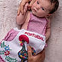 baby, infant, child, pink_clothing, gingham, rooster, embroidered, portugal, hand, tattoo, blanket, soft_texture, cute, portrait, newborn, holding, skin, face, eyes, gentle