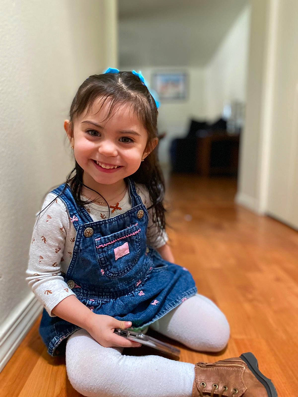 Yaliah is registered to the contest to win money with this photo: baby_toddler_clothing, child, collar, dress, electric_blue, flooring, fun, happy, hardwood, human_leg, joy, knee, person, sitting, skin, sleeve, smile, sock, thigh, toddler