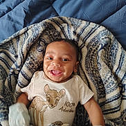 Aubrey joined the competition — help win amazing prizes! baby, infant, smiling, blanket, patterned_blanket, bedspread, clothing, onesie, cartoon, deer, cute, happy, portrait, child, indoor, young_child, mittens, lying_down, cozy, adorable