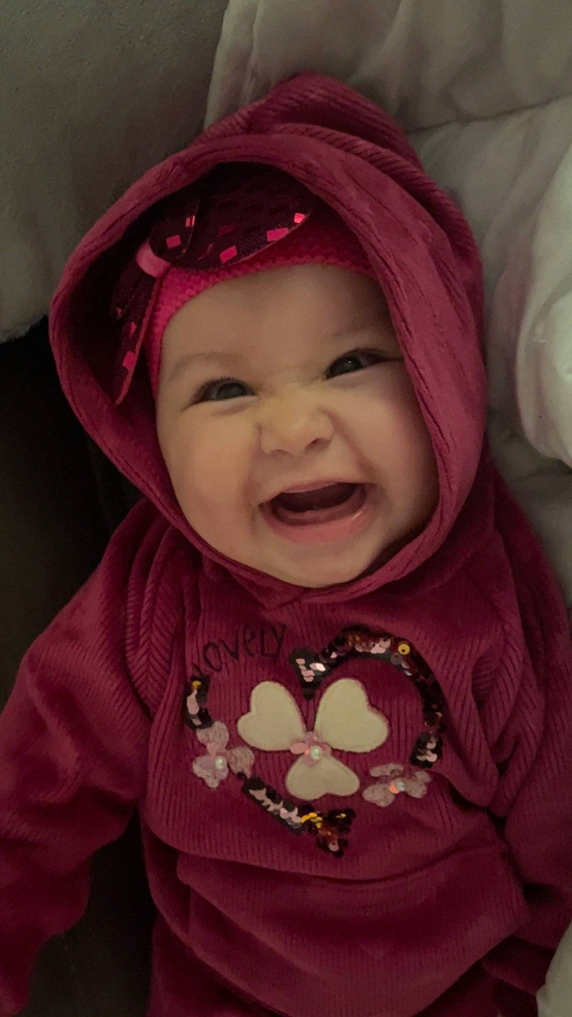 Naïla participe au concours pour gagner de l'argent avec cette photo : baby, baby_toddler_clothing, cap, cheek, eye, eyebrow, happy, head, headwear, human_body, lip, mouth, nose, outerwear, person, pink, purple, skin, sleeve, smile