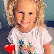 Lilou a rejoint le concours — aidez-le/la à gagner de superbes lots ! blonde_hair, bracelet, casual_clothing, child, curly_hair, denim_shorts, door, floor_tiles, fruit_print, girl, happy, heart_emoji, indoor, light_skin, portrait, smiling, standing, wall_switch, white_tshirt, young