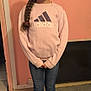 child, girl, braid, standing, sneakers, jeans, sweatshirt, indoor, wall_art, pink_wall, floor, casual_clothing, smile, portrait, long_hair, youth, fashion, cute, home, childhood