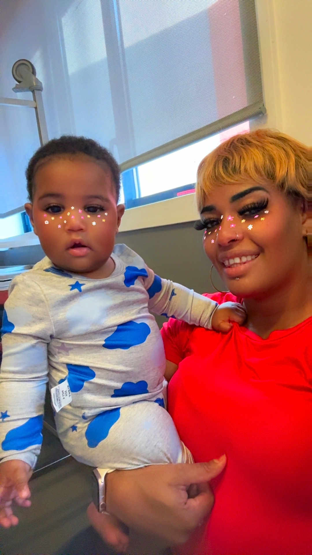 Cheikhou a rejoint le concours — aidez-le/la à gagner de superbes lots ! adult, casual, child, curtains, face, flower_filter, hair, hand, happy, holding, indoor, pajamas, person, red_shirt, skin, smile, toddler, watch, window, woman