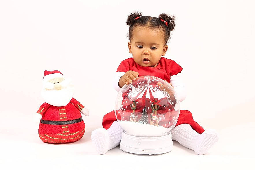 Nora a rejoint le concours — aidez-le/la à gagner de superbes lots ! baby, baby_toddler_clothing, carmine, child, christmas_ornament, doll, event, fictional_character, happy, holiday, holiday_ornament, interior_design, ornament, person, recreation, santa_claus, sitting, sleeve, souvenir, toddler