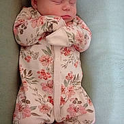 Arya joined the competition — help win amazing prizes! baby, sleeping, infant, onesie, floral_pattern, headband, pink_bow, feet, hands, soft_surface, cute, peaceful, child, portrait, newborn, resting, indoors, clothing, person, babywear