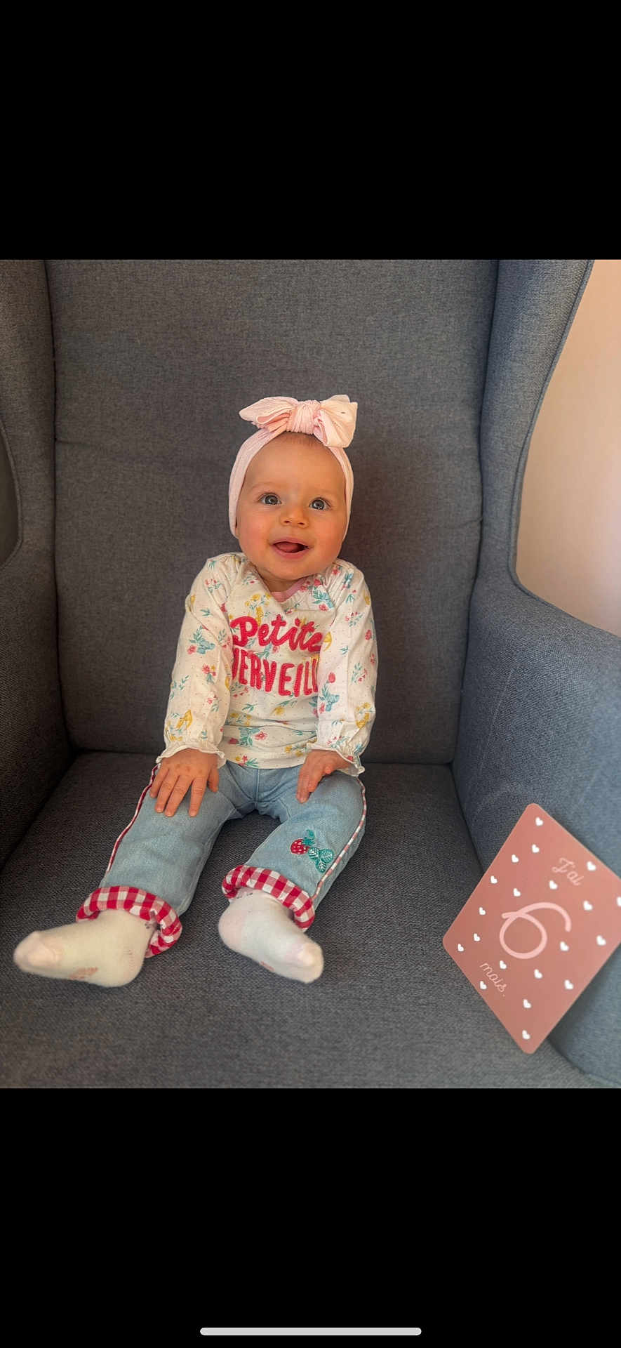 Danyela participe au concours pour gagner de l'argent avec cette photo : baby, child, smiling, headband, pink_bow, jeans, floral_top, sitting, gray_chair, milestone_card, happy, cute, indoor, portrait, young_child, sock, comfortable, headwear, small_person, casual_clothing