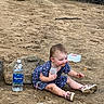 baby, child, toddler, outdoor, sandy_ground, woodland, rocks, bottle, water, dress, polka_dots, sitting, smiling, portrait, face, curious, shoes, nature, adventure, daylight