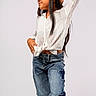 Briannie is registered to the contest to win money with this photo: child, girl, pose, white_blouse, jeans, star_patch, long_hair, glasses, fashion, confident, standing, portrait, casual, studio, young, smile, hands_on_hips, textured_clothing, denim, isolated_background