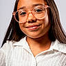 Briannie is registered to the contest to win money with this photo: apparel, background, casual, child, closeup, confident, eyewear, face, fashion, friendly, girl, glasses, happy, long_hair, person, portrait, smile, studio, white_shirt, young