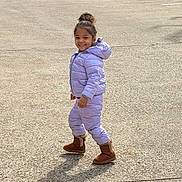 Ashley is registered to the contest to win money with this photo: boots, bun_hair, candid, child, face, girl, happy, outdoor, parked_car, parking_lot, pavement, puffer_jacket, purple_jacket, shadow, single_person, smiling, snowsuit, toddler, walking, winter_clothing