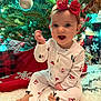 baby, child, christmas_tree, holiday, pajamas, red_bow, festive, presents, decorations, ornament, lights, carpet, smiling, indoors, celebration, cute, sitting, winter, happy, headband