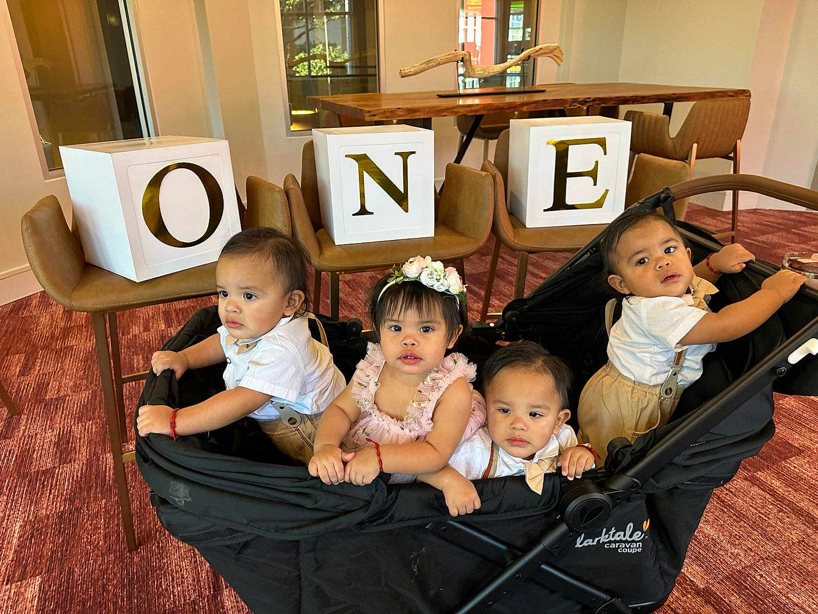 Cuatrillizos joined the competition — help win amazing prizes! toddler, child, stroller, indoor, carpet, wooden_table, chairs, blocks, letters, one, flower_headband, white_shirt, curious, group, people, baby, red_bracelet, expression, caravan_coupe, furniture