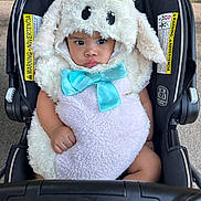 Marlene joined the competition — help win amazing prizes! baby, black, blue_bow, child, costume, cute, expression, eyes, face, fur, grass, hands, infant, outdoor, plush, sheep, sidewalk, sitting, stroller, warning_labels