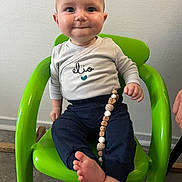 Elio participe au concours pour gagner de l'argent avec cette photo : accessories, baby, bodypart, bracelet, chair, clothing, face, finger, furniture, hand, head, jewelry, necklace, pants, person, photography, portrait, sitting, sleeve, t_shirt