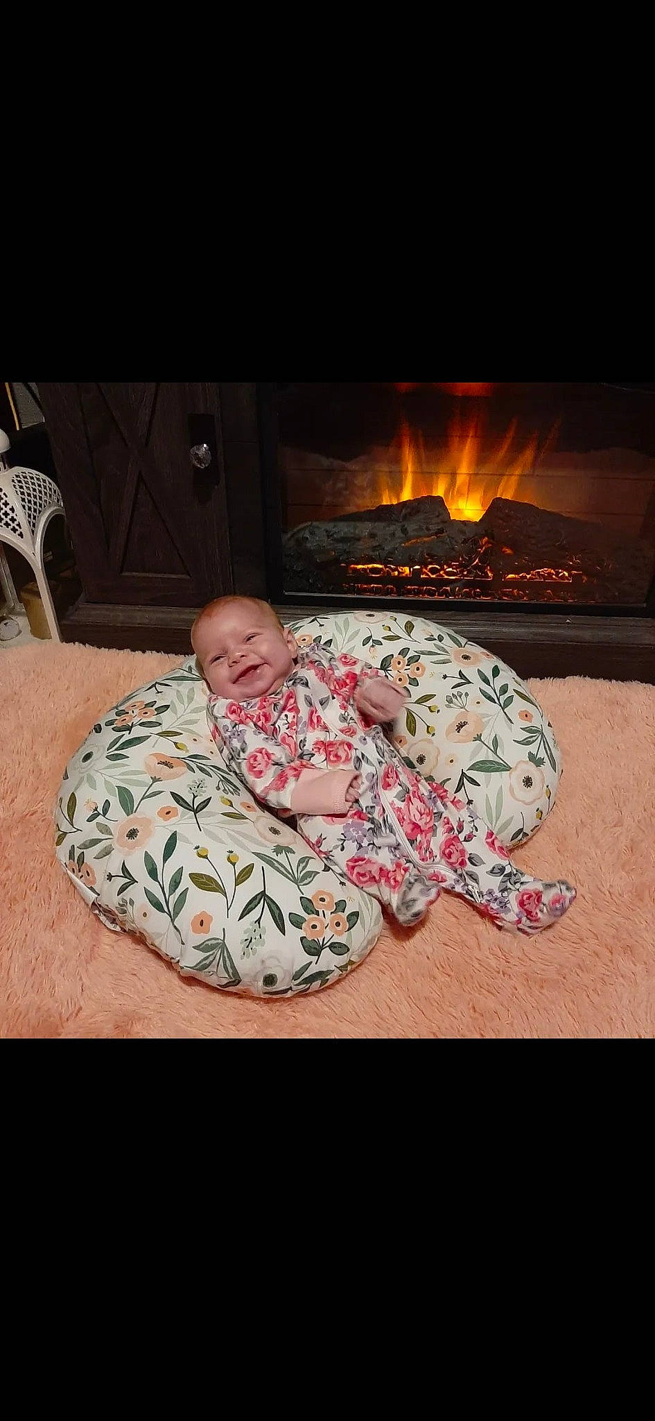 Legacie is registered to the contest to win money with this photo: baby, chair, child, comfort, fire, fireplace, flesh, flooring, gas, hearth, heat, joy, linens, military_camouflage, pattern, person, room, sitting, stove, toddler