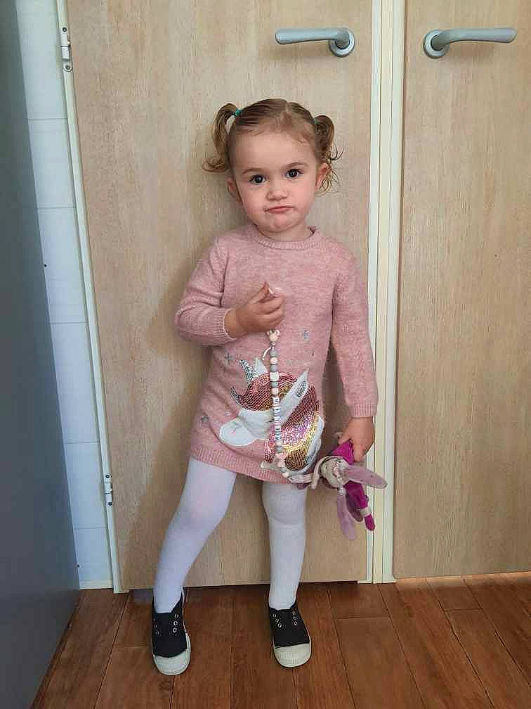 Kélia participe au concours pour gagner de l'argent avec cette photo : baby_toddler_clothing, child, door, fashion_design, flooring, hardwood, human_leg, knee, magenta, neck, pattern, person, pink, sitting, sleeve, sock, t_shirt, thigh, toddler, waist