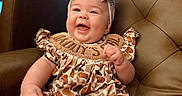 Wrenley joined the competition — help win amazing prizes! baby, child, smiling, bow, headband, romper, patterned_clothing, leather_chair, happy, portrait, sitting, infant, cute, indoors, furniture, skin, feet, hand, face, person