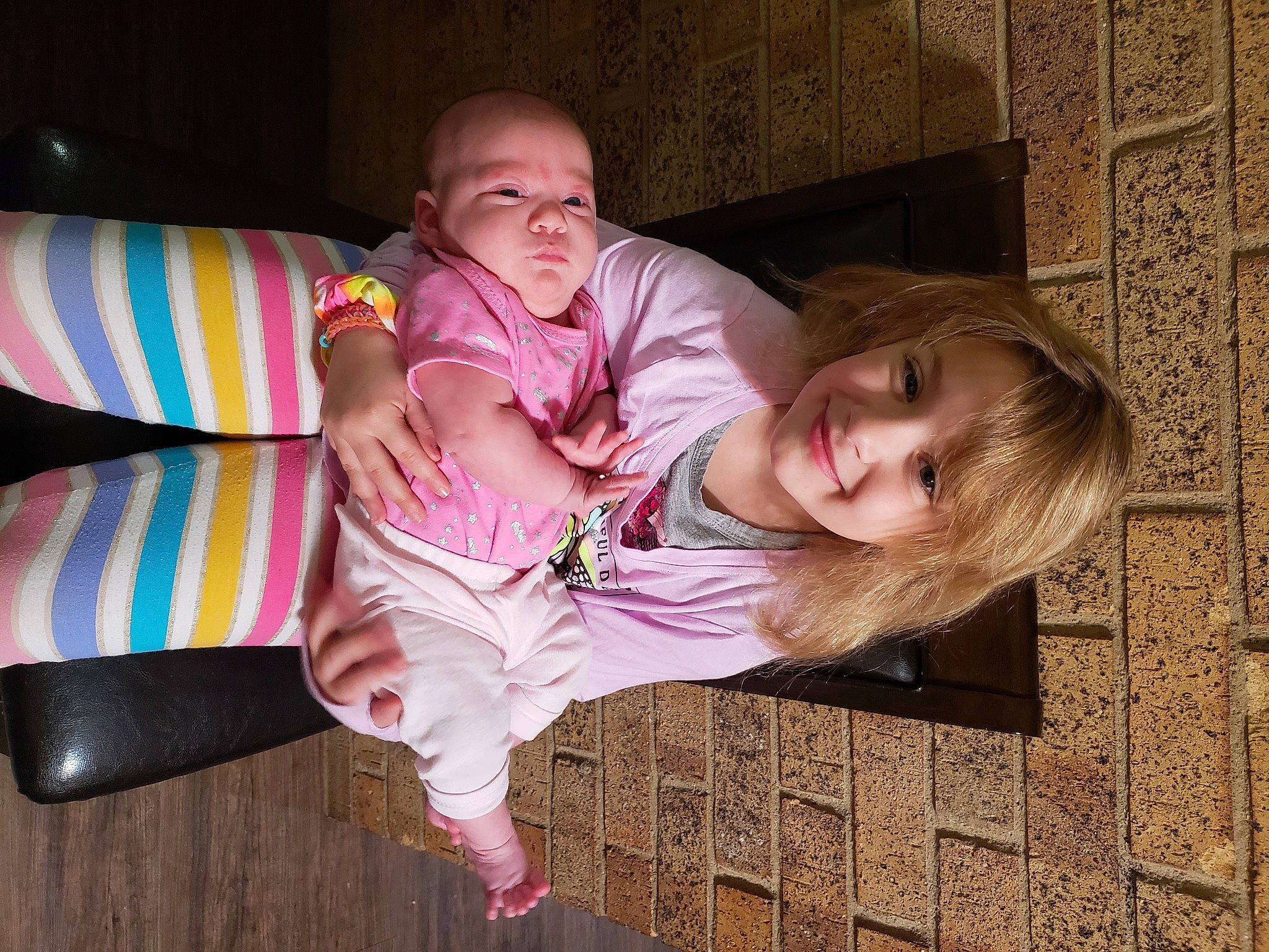 Mia is registered to the contest to win money with this photo: baby, baby_toddler_clothing, cheek, child, comfort, facial_expression, flooring, foot, fun, happy, hardwood, joy, leg, magenta, person, pink, sitting, skin, smile, sock