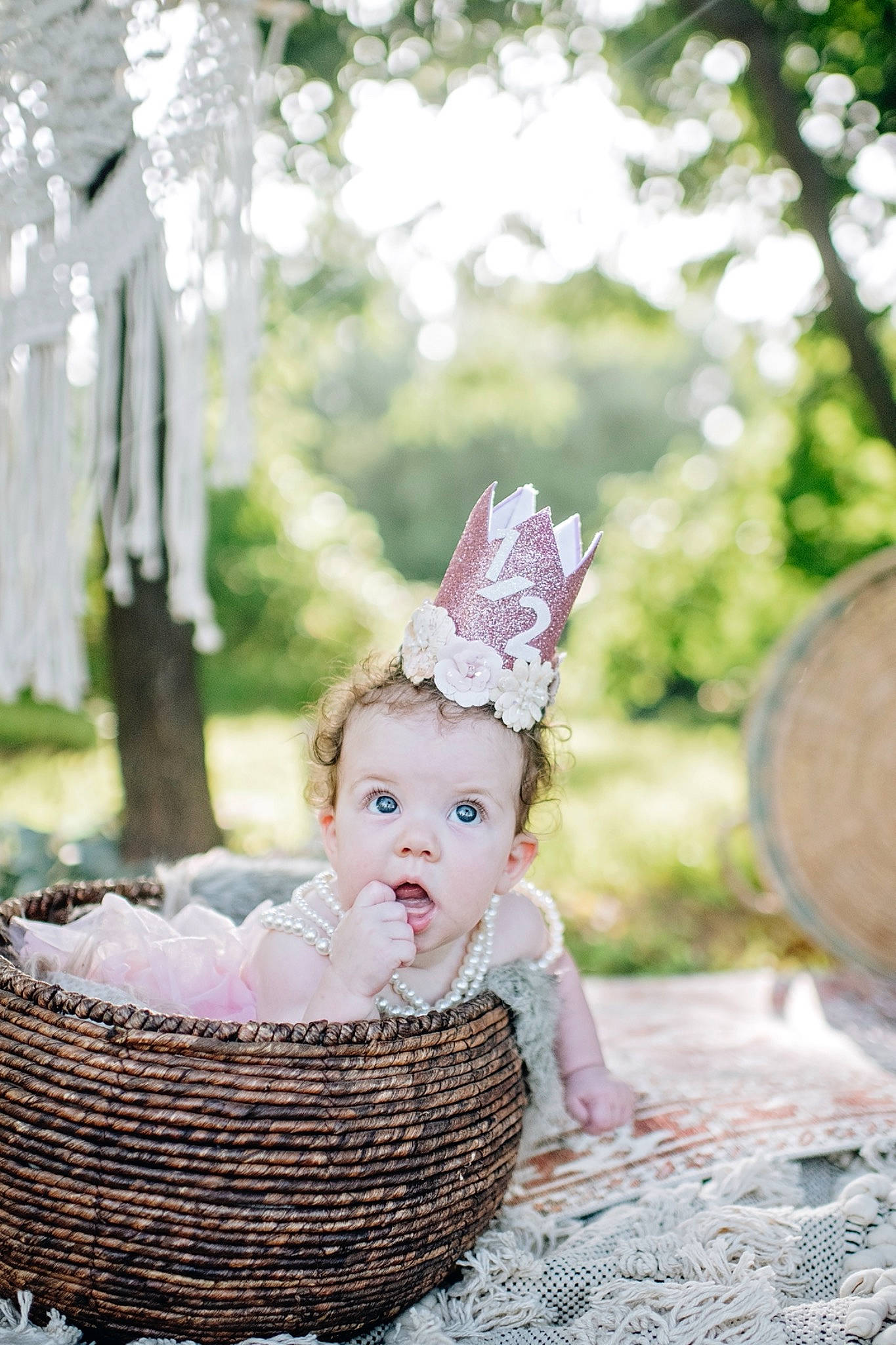 Oaklee is registered to the contest to win money with this photo: baby, basket, child, costume_hat, event, fashion_accessory, fawn, grass, hair_accessory, happy, hat, headgear, headpiece, people_in_nature, person, plant, sitting, surprise, toddler, tree