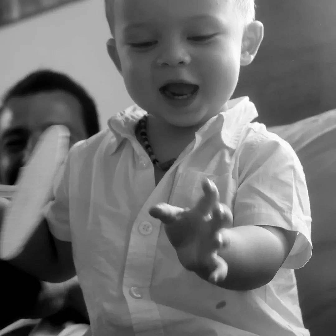 Maël participe au concours pour gagner de l'argent avec cette photo : arm, baby, baby_toddler_clothing, black_and_white, cheek, ear, finger, flash_photography, gesture, happy, iris, mouth, person, skin, sleeve, smile, standing, style, thumb, toddler