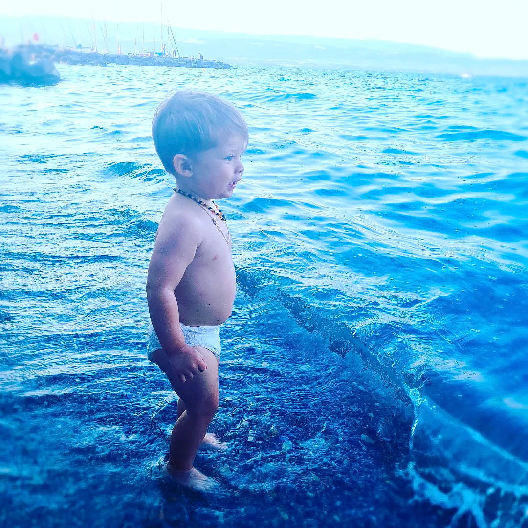 Maël participe au concours pour gagner de l'argent avec cette photo : azure, beach, blue, body_of_water, child, electric_blue, flash_photography, fun, happy, horizon, lake, leisure, people_in_nature, people_on_beach, person, recreation, sky, toddler, water, wave