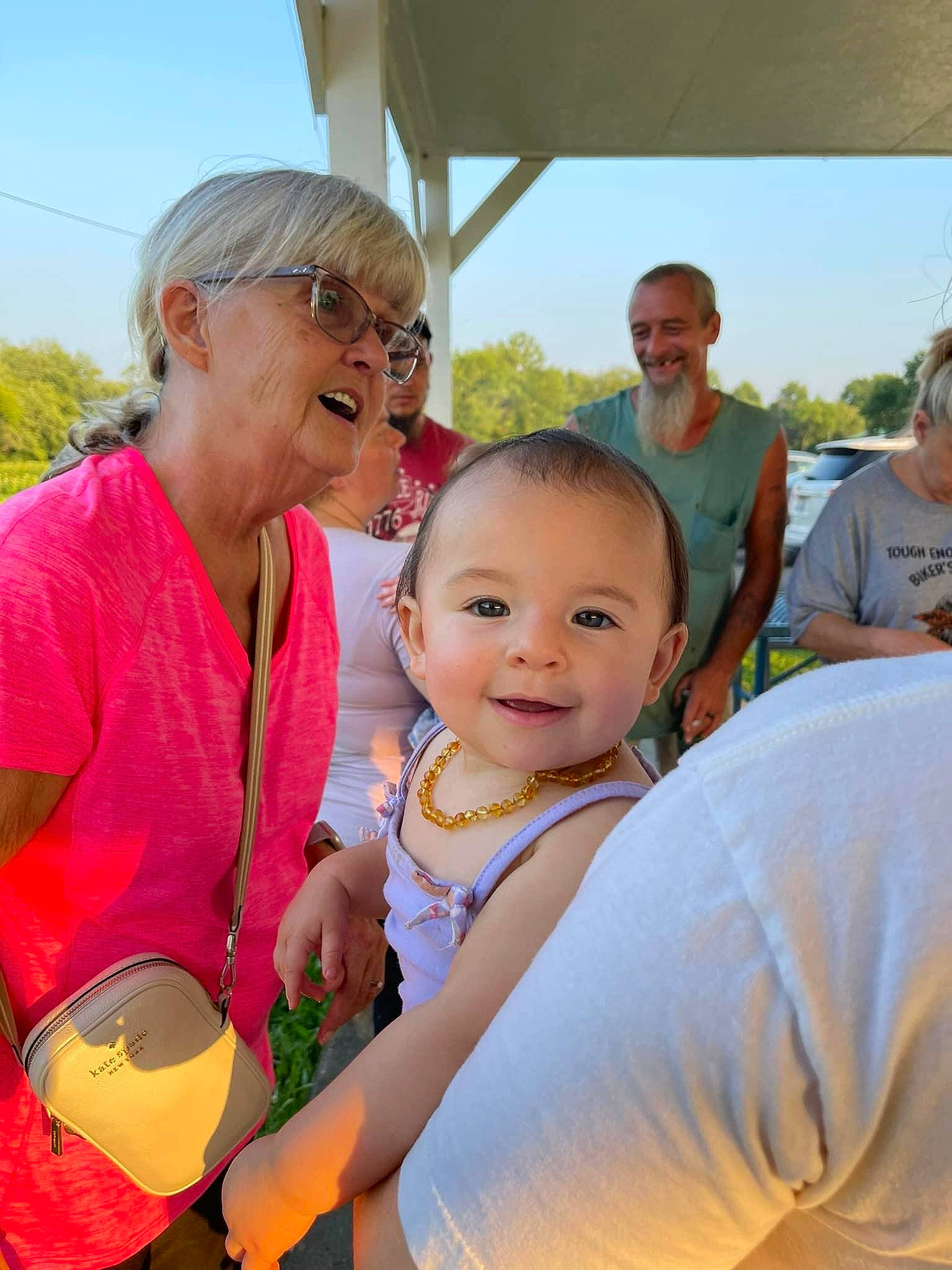 Laura is registered to the contest to win money with this photo: baby, child, community, event, facial_expression, fun, grass, happy, joy, leisure, people, people_in_nature, person, recreation, sky, smile, summer, sunglasses, t_shirt, toddler