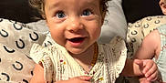 Wrenley joined the competition — help win amazing prizes! toddler, child, curly_hair, blue_eyes, smiling, bed, pillow, floral_dress, pacifier_clip, indoor, person, cute, happy, sitting, skin, hand, face, infant, candid, young_child