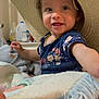 Wrenley joined the competition — help win amazing prizes! toddler, child, hat, straw_hat, blanket, toy, indoor, smiling, blue_shirt, floral_pattern, person, face, hand, foot, curly_hair, cozy, home, cute, playful, baby