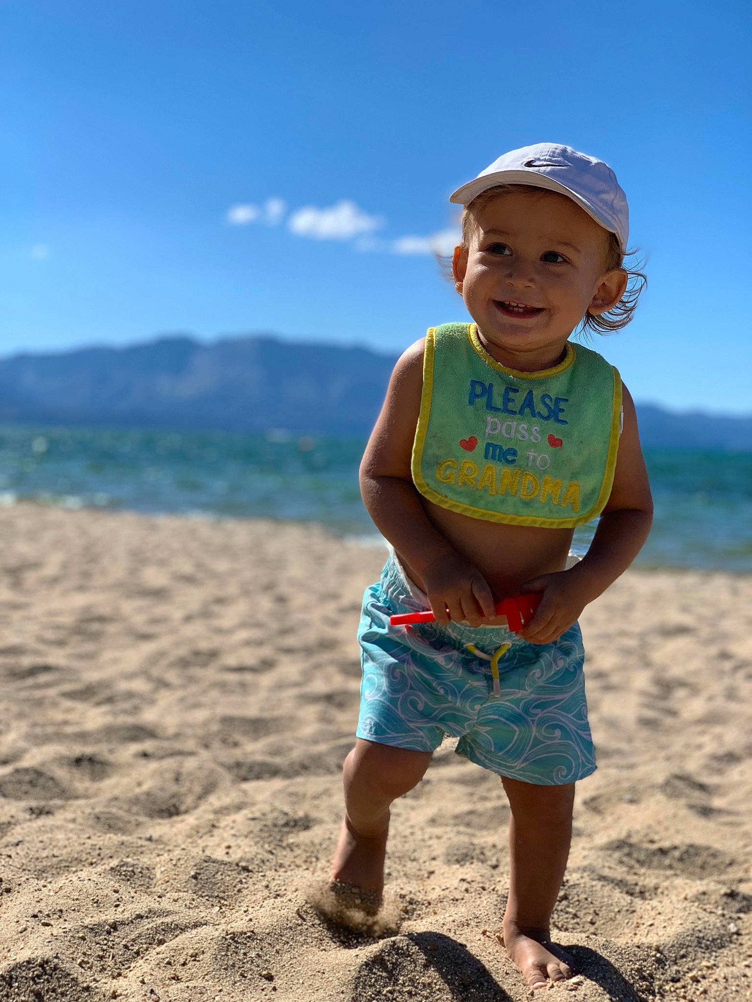 Kiyan is registered to the contest to win money with this photo: beach, child, fashion_accessory, fun, happy, headgear, headwear, holiday, joy, ocean, person, photography, play, sand, sea, shorts, smile, standing, summer, sun_hat