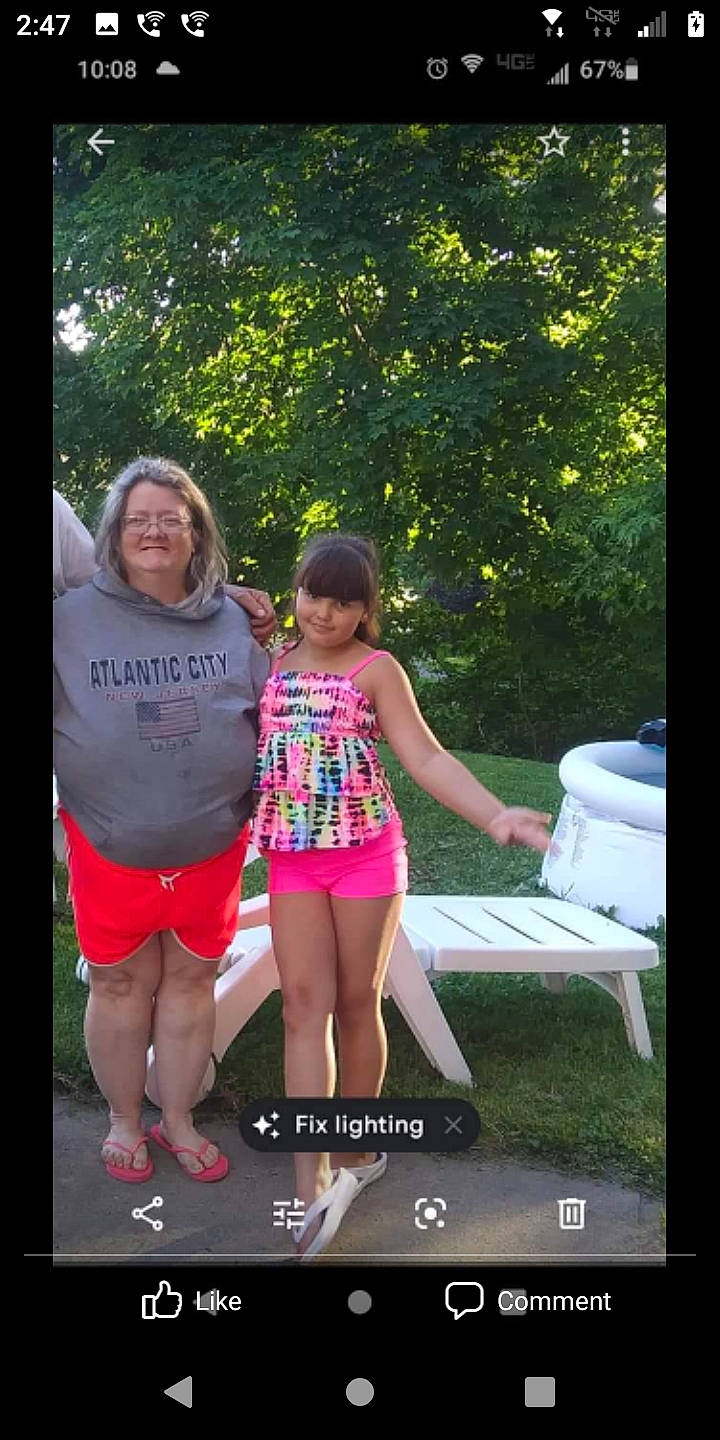 Stephanie is registered to the contest to win money with this photo: advertising, display_device, event, flash_photography, fun, grass, happy, human_leg, joy, leg, leisure, magenta, person, photo_caption, pink, plant, recreation, shorts, smile, t_shirt