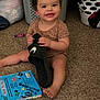 toddler, child, smiling, carpet, shoe, nike, laundry_basket, clothing, book, indoor, playful, happy, baby, toy, foot, hand, room, casual, household, sitting