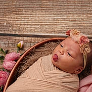 Zoey joined the competition — help win amazing prizes! newborn, baby, wrapped, swaddle, headband, flowers, pink, tongue_out, cute, infant, sleepy, soft, portrait, closeup, wooden_background, decor, peaceful, adorable, baby_bed, floral