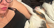 Némhezys a rejoint le concours — aidez-le/la à gagner de superbes lots ! animal, black_clothing, black_dog, blanket, calico_cat, casual, comfort, couch, cozy, glasses, home, indoor, laying_down, necklace, pet, portrait, relaxing, resting, sleeping_cat, woman