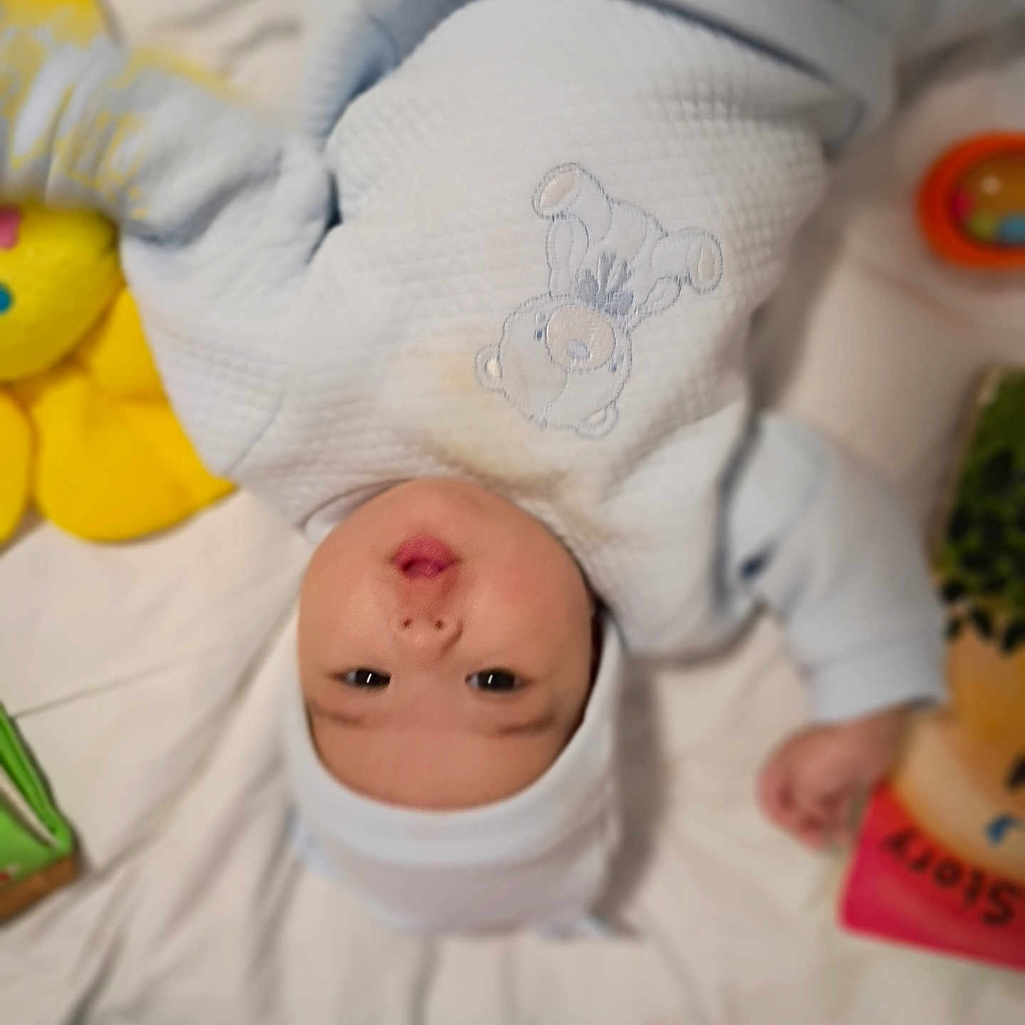 Bella Mia is registered to the contest to win money with this photo: baby, bed, blanket, child, clothing, colorful, comfort, cute, face, hat, indoor, infant, lying_down, onesie, person, playtime, pout, soft_toy, teddy_bear, toy