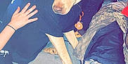 Diesel joined the competition — help win amazing prizes! dog, black_shirt, cap, couch, hand, indoor, clothing, water_jug, person_hand, floor, slippers, seated, brown_dog, casual, relaxed, furniture, pet, domestic, animal, side_view