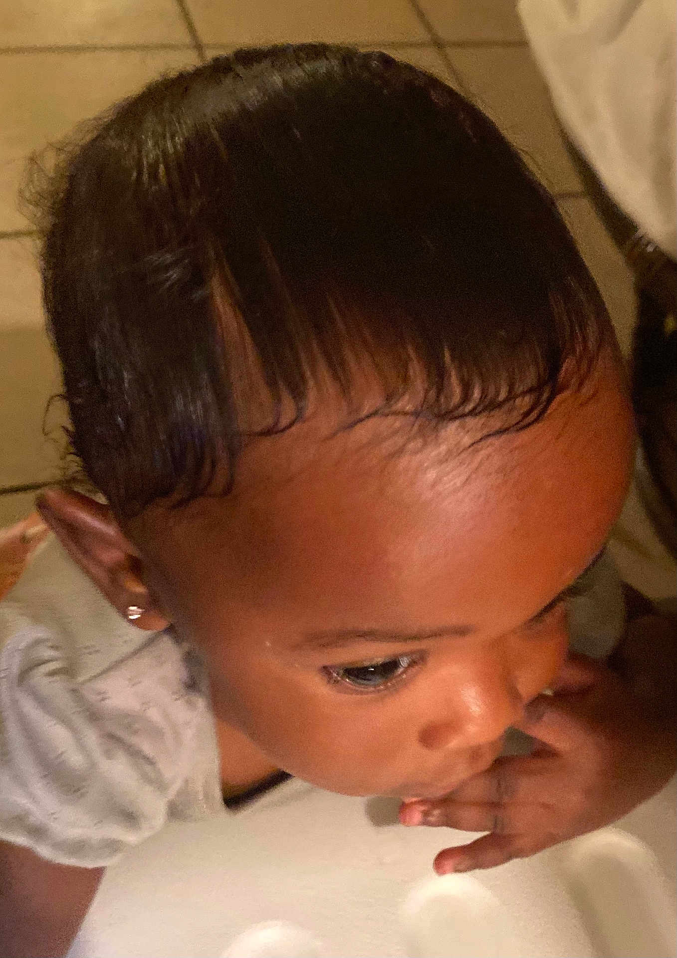 Majestie is registered to the contest to win money with this photo: child, toddler, face, hair, skin, earring, hand, fingers, curious, indoor, floor, tile, clothing, short_sleeves, portrait, closeup, baby, person, young_child, looking_down